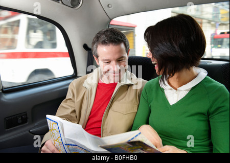 Couple reading map in London Taxi Stock Photo