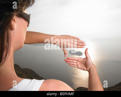 Woman framing a boat with her hands Stock Photo