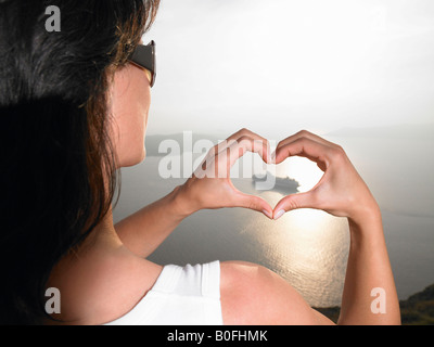 Woman framing a boat with her hands Stock Photo