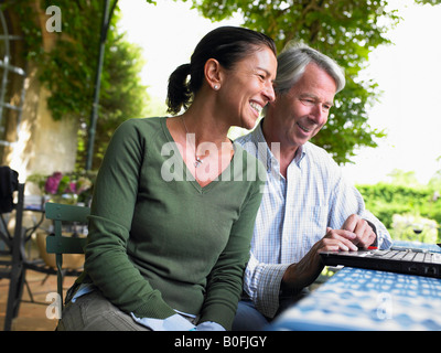 Couple on computer, laughing Stock Photo