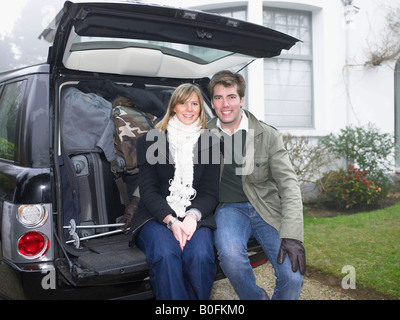 Couple in front of packed car Stock Photo