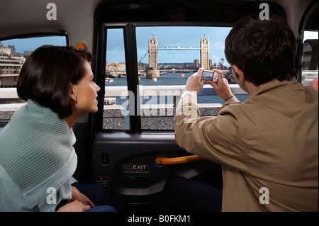 Couple in taxi, view of Tower Bridge Stock Photo