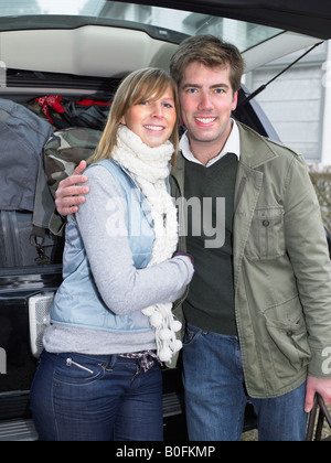 Couple in front of packed car Stock Photo