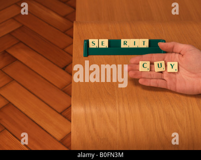 Hand holding letters from board game Stock Photo