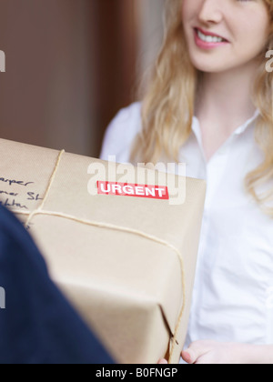 Woman signing for urgent delivery Stock Photo