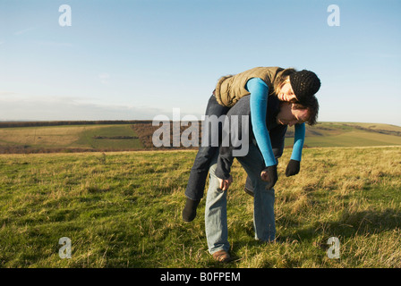 Woman rests on man's back Stock Photo
