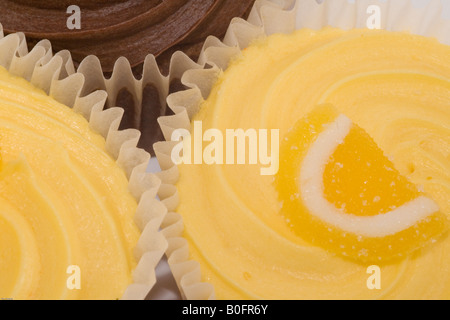 Lemon buns with butter icing and sugared lemon and a chocolate bun. Stock Photo