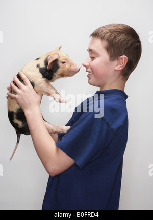 Boy holding piglet Stock Photo