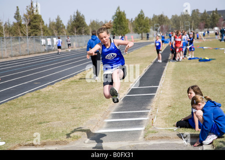 Middle school children junior high school take part in a school track meet on a spring day This is the girl s long jump Stock Photo