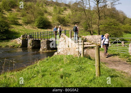 UK Derbyshire Peak District National Park Monsal Dale family of walkers on bridge crossing River Wye Stock Photo