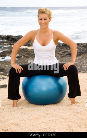 Fit young woman sitting on exercise ball at gym Stock Photo - Alamy