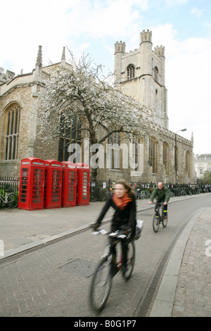 University students cycling  past St Marys Church, Cambridge city centre, Cambridge UK Stock Photo