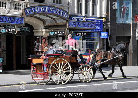 London Strand tourists in open horse and carriage passing the Vaudeville Theatre Stock Photo