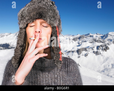 Young woman in hat smoking Stock Photo