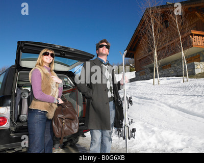 Young man and woman in front of car Stock Photo