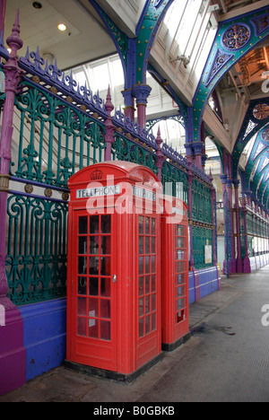 Interior of Smithfield Meat Market with 2 traditional red phone boxes in the foreground London UK Stock Photo