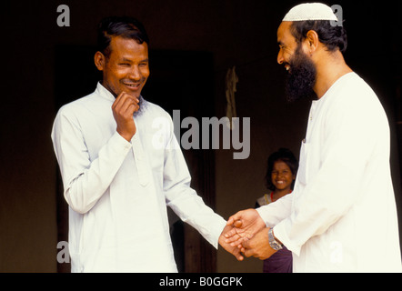 A blind man greeting a friend wearing a skullcap, Manipur, India. Stock Photo