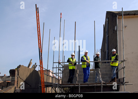A group of builders posing for photographer on building site, UK Stock Photo
