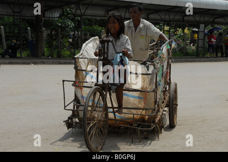 everyone has to work, no exception! little khmer girl is working by using cart carry contraband from thai side to cambodian side Stock Photo