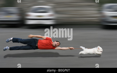 Disobedient dog running and dragging a man by the leash Stock Photo