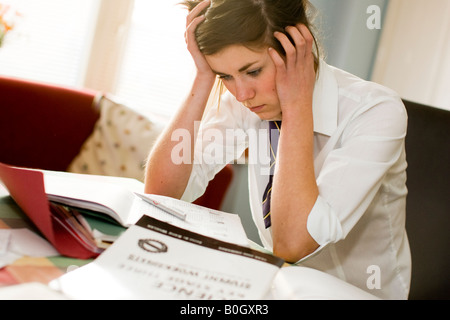 schoolgirl revising for gcse exams looking bored Stock Photo