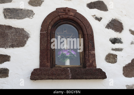 Crucifix on display in a glassed in alcove on the side of the church in Masca Tenerife Canary Islands Spain Stock Photo