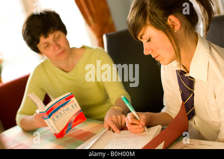 mother helping her daughter with homework Stock Photo