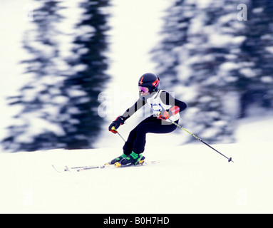 A 14 year old downhill racer speeds through a turn in a race Stock Photo