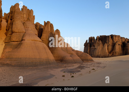 Eroded rock formations rising out of desert sand in Tin Akachaker, Tassili du Hoggar, Wilaya Tamanrasset, Algeria, North Africa Stock Photo