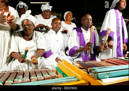 Male and female marimba players performing with the choir at a church service in Douala, Cameroon, Africa Stock Photo