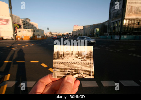 Then and now, hand holding an old black and white photo of Potsdamer Platz or Potsdam Square showing the Berlin Wall, Berlin, G Stock Photo
