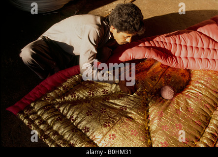 A man sewing designs on a blanket, Quetta, Pakistan. Stock Photo