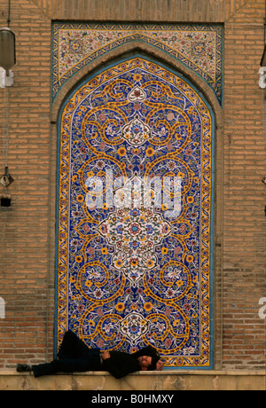 A man sleeping on a ledge outside the Khomeini Mosque, Tehran, Iran. Stock Photo