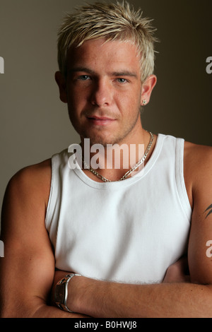 Portrait of young  tattooed male against a dark background. Stock Photo