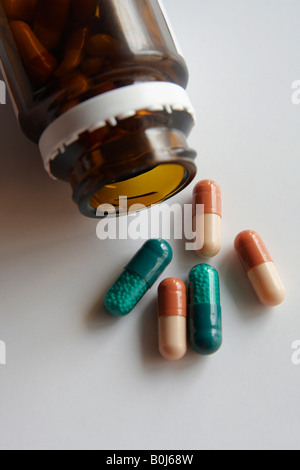 Bottle with pills spilling out on white background Stock Photo