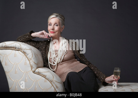 Mature Woman Having Glass of Champagne Stock Photo