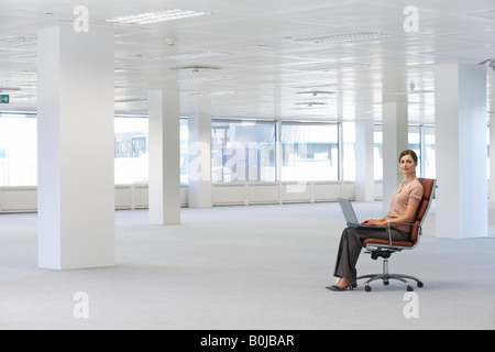 Woman Using Laptop in Empty Office Space Stock Photo