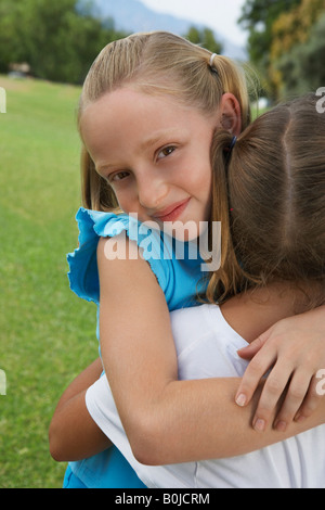 Portrait of two girls hugging outdoors Stock Photo - Alamy
