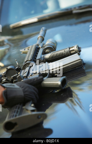 Close-up of police weapon on car bonnet Stock Photo