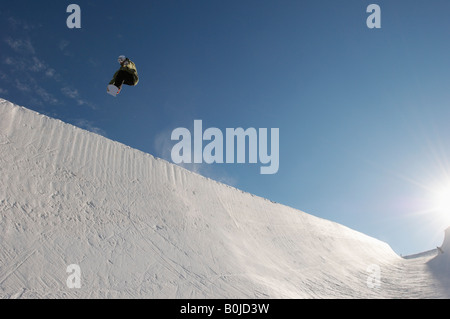 Silhouette of teenage snowboarder on halfpipe Stock Photo