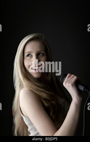 Young woman singing in studio Stock Photo