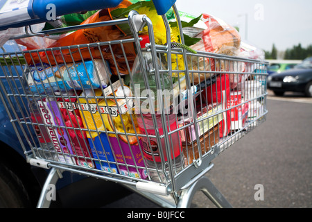 Supermarket shopping trolley full of groceries. Stock Photo