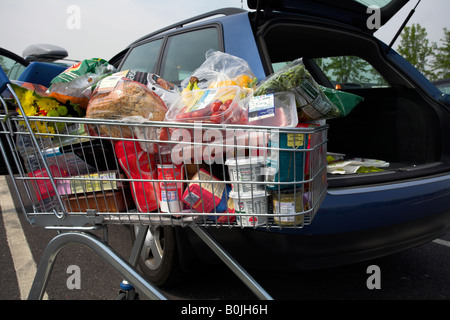 Supermarket shopping trolley full of groceries. Stock Photo