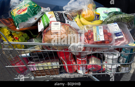 Supermarket shopping trolley full of groceries. Stock Photo