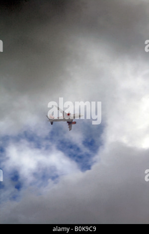 easyjet plane flying through dark clouds in sky Stock Photo