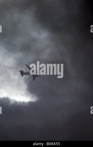 easyjet plane flying through dark clouds in sky Stock Photo