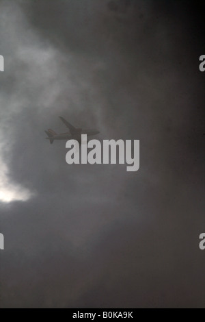 easyjet plane flying through dark clouds in sky Stock Photo