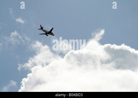 easyjet plane flying through dark clouds in sky Stock Photo