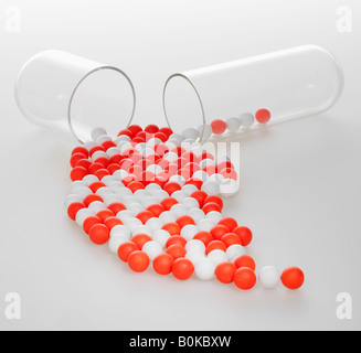 Red and White Pills Spilling Out From Capsule Stock Photo
