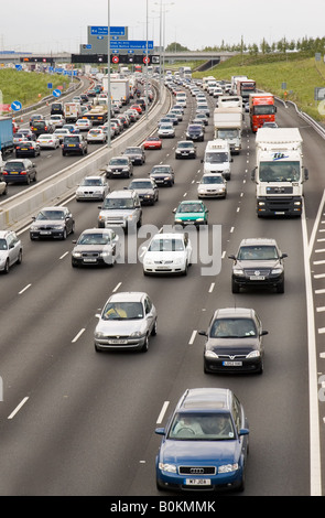 Four lane traffic cars and trucks motoring in congestion on M25 motorway London United Kingdom Stock Photo